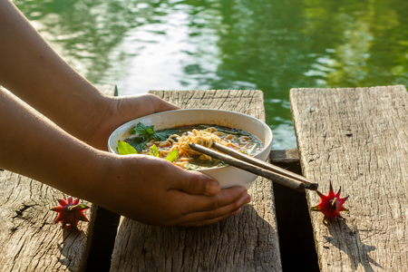 Instant noodles in wooden bowl on wood backgroundの写真素材
