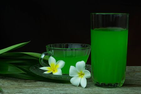 Glass of cold Pandan juice - healthy food against wood,
With pandan green on the old wooden floorの写真素材
