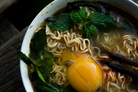Instant noodles in wooden bowl on wood background