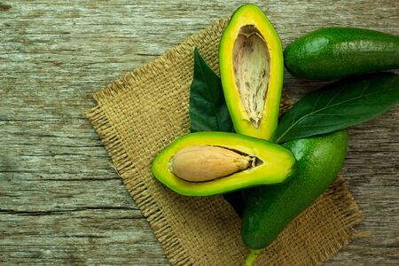 food background with fresh organic avocado on old wooden table, top view, copy space.