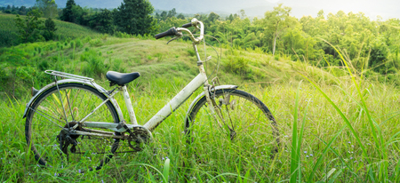 Old white bike parked in the meadow on the mountain.
Behind the mountain at sunset.の写真素材
