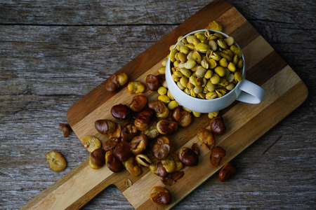 Soybeans dried in glass,Broad beans are dried on a butcher on an old piece of wood.の写真素材