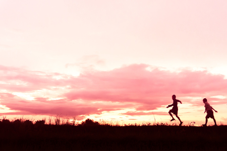 silhouette of a Boy playing on the sunset background.の写真素材