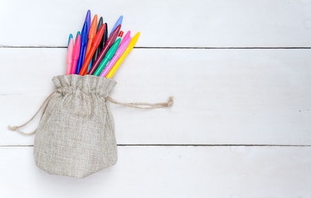 Sack Bag with colorful pens,on white woods.の写真素材