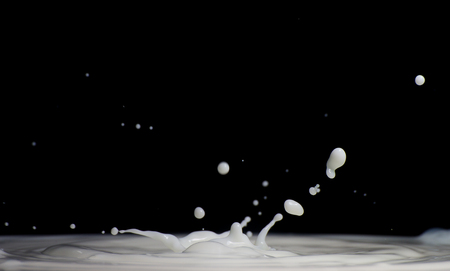 milk splash in black background.の写真素材