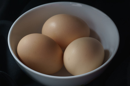 Brown eggs in a white cup ready to eat.