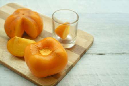 Persimmon on a white background, persimmon orange in front view.