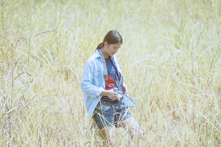 Girl takes photographs with vintage photo camera outdoor,Woman photographed in a meadow with a...