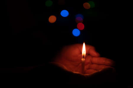 The hand that protects the candles in the dark.の写真素材