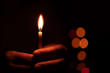 The hand that protects the candles in the dark.の写真素材