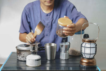 Asian boy learning to make coffee with moka pot.の写真素材