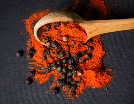whole and ground pepper with a Wooden Spoon