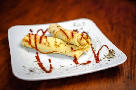 Delicious pancakes with meat, spices and sauce on a white plateの写真素材