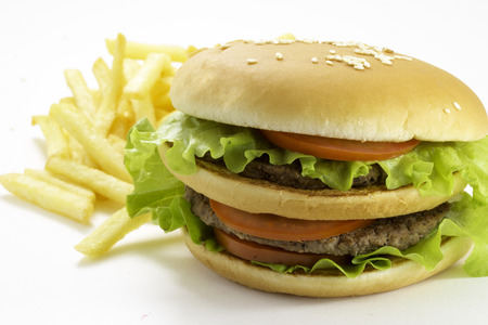 Big and tasty hamburger and fried potatoes isolated on white の写真素材