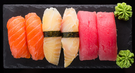 Sushi nigiri set on a stone plate over black backgroundの写真素材