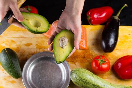 chef slicing the avocado closeup on a wooden board