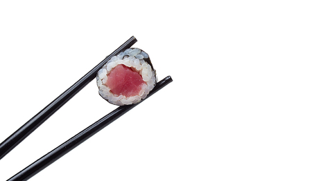 Sushi roll in chopsticks isolated on white backgroundの写真素材