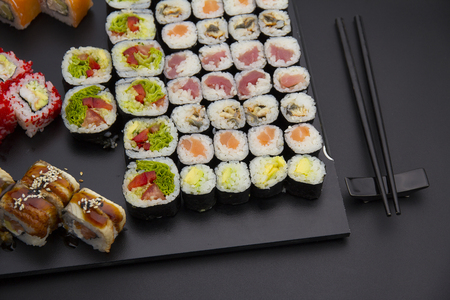 Sushi set on a black plate over dark backgroundの写真素材