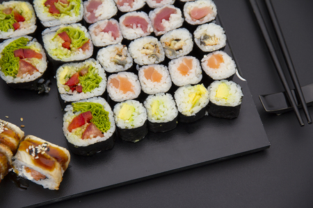 Sushi set on a black plate over dark backgroundの写真素材