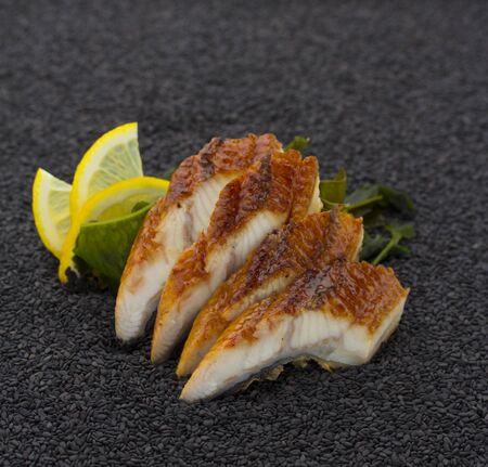 Eel sashimi over back sesame background