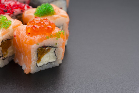 Japanese cuisine. Set of sushi mix roll with different fresh ingredients over black backgroundの写真素材