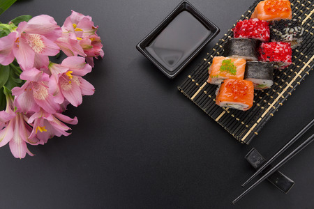 Japanese cuisine. Set of sushi mix roll with different fresh ingredients over black backgroundの写真素材
