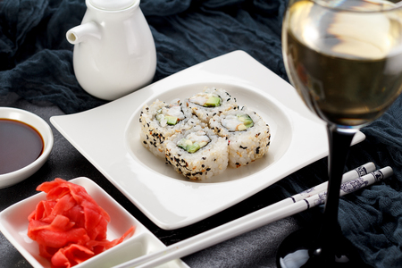 Sushi roll on a white plate, decorated like in restaurant over dark concrete backgroundの写真素材