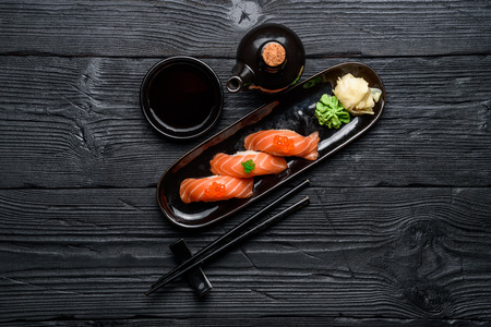 Japanese cuisine. Salmon sushi nigiri with soy sauce on a dark wooden background.の写真素材