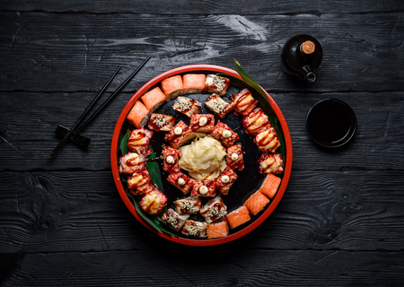 Japanese cuisine. Sushi set on a round plate over dark wooden background.の写真素材