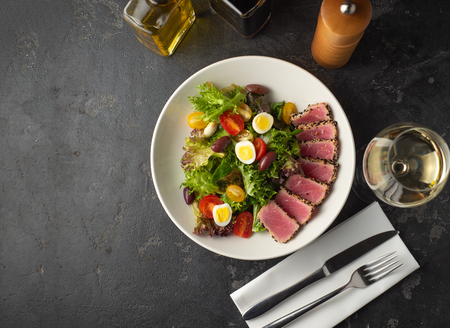 Sliced Steak of tuna in sesame and a salad of fresh vegetables and quail eggs.の写真素材