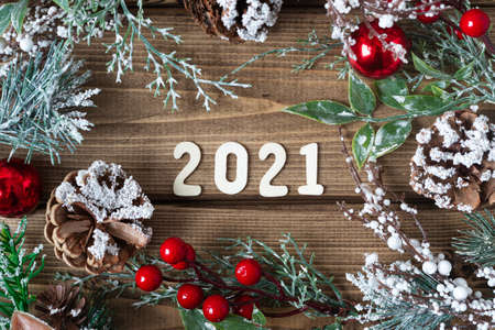 New year composition. Christmas wreath with fir branches decorations on old dark wooden background with 2021 letters text, flat lay top view.の写真素材