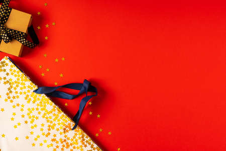Gift box or present box with black golden ribbon on red background.の写真素材