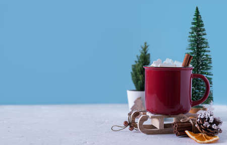 Winter hot drink, cacao with marshmallows and cinnamon or spicy hot chocolate in red cup. Merry...