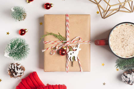 Christmas eco gift with empty tag. Glowing snow bokeh, coniferous branch. Winter holidays mock up on white background. Zero waste, plastic freeの写真素材