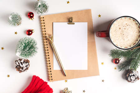 Desktop blank note pad. Flat lay of white working table background with cup of coffee and Christmas...