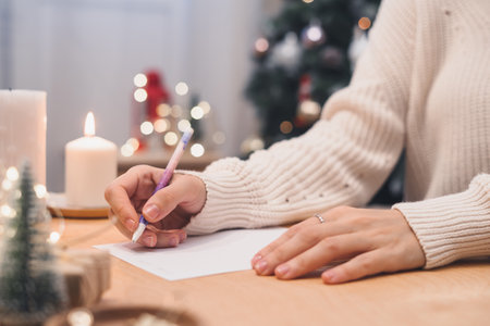 Goals plans make to do and wish list for new year christmas concept writing in notebook. Woman hand holding pen on notepad at home on winter holidays xmas.の写真素材