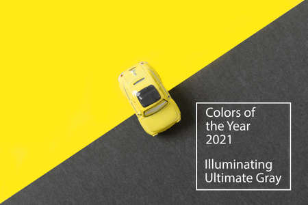 Yellow car toy on trendy yellow gray background with copy space. Illuminating Yellow and Ultimate...