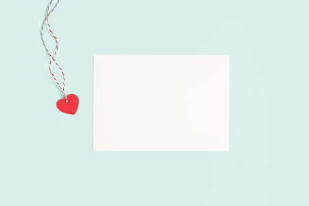 Desktop blank paper note pad. Flat lay of blue working table background with Valentine gift, letter, heart shape and decoration. Top view, mock up greeting cardの写真素材