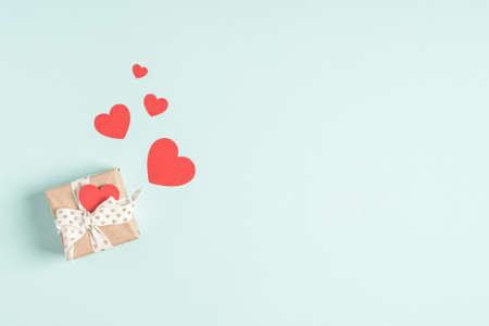 Background with gift and hearts with free space for text on pastel blue background. Greetings. Copy...