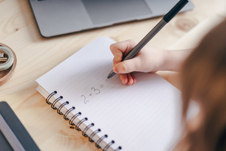 Distance learning online education. Caucasian smile kid boy studying at home with laptop, writing in...