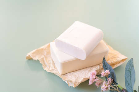 Flower, craft paper, cotton fabric, soap, over green background. Zero waste, natural organic bathroom tools. Plastic free life. Ecological skin care, body treatment conceptの写真素材