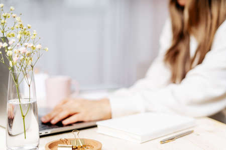 Distance learning online education and work. Business woman writes goals, plans, make to do and wish list in notebook on desk, working from home office. Using laptop.の写真素材