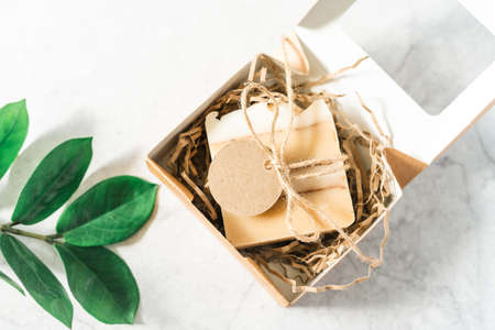 Soap in Craft Gift box or present box with bow on white background with mockup label tag. Copy space for text and design. Package, zero waste, plastic free, eco friendly natural organic concept.の写真素材