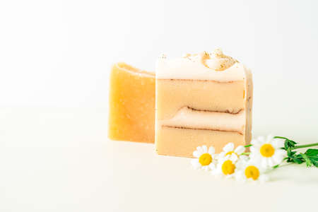 Homemade herbal Soap with chamomile Flowers on white marble background. Zero waste, natural organic bathroom cosmetics. Plastic free life. Ecological skin care, body treatment conceptの写真素材