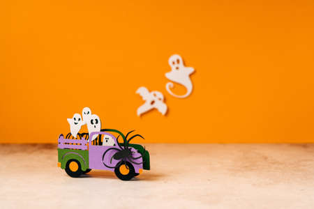 Happy halloween holiday concept. Halloween handmade paper decorations, spiders, ghosts in car, bats, boo text on orange background. Halloween festival party, greeting card mockup with copy space.の写真素材