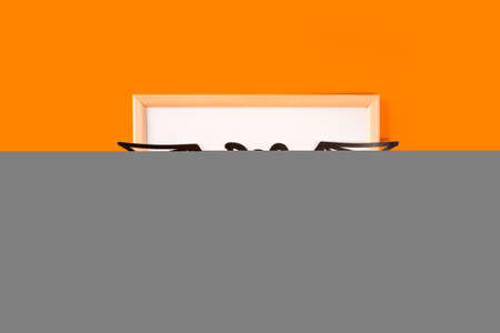Happy halloween holiday concept. Jack o lantern, handmade paper decorations, boo text with bat wings in frame on orange background. Halloween festival party, greeting card with copy space.の写真素材