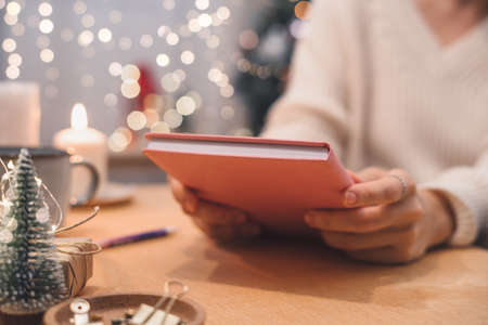 Goals plans make to do and wish list for new year christmas concept writing in notebook. Woman hand holding pen on notepad at home on winter holidays xmas.の写真素材