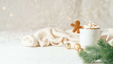 Gingerbread man cookie in cup of hot cocoa or coffee with marshmallow, fir tree, cinnamon and warm...