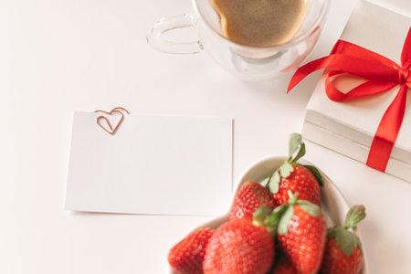 Spring, summer still life composition for valentine day. Blank greeting card mockup scene with heart shaped cup of coffee, strawberries, and roses flowers. Breakfast in bed. Flat lay, top viewの写真素材
