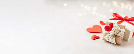 Valentines Day banner. Gift or present box with red bow and heart shape on lights background. Copy...